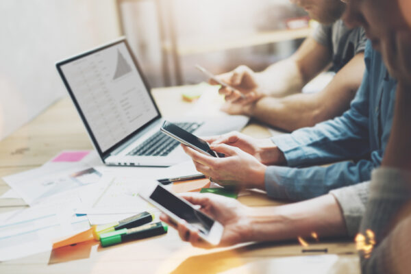 Office workers using mobile, laptop and computing devices